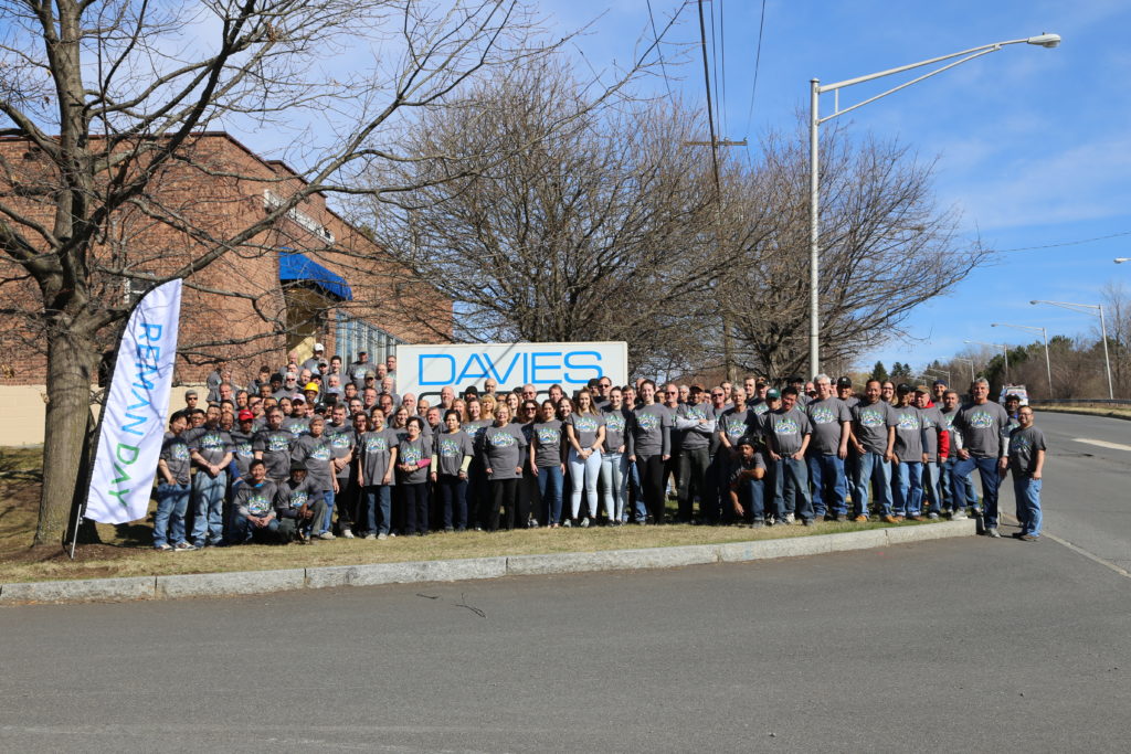 Davies Office team posing outside by company sign